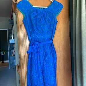 Turquoise dress with vibrant blue floral lace covering and matching ribbon.